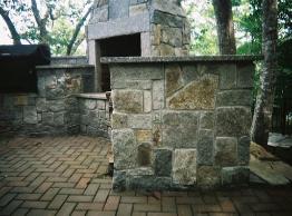 custom built granite outdoor kitchen with granite fireplace